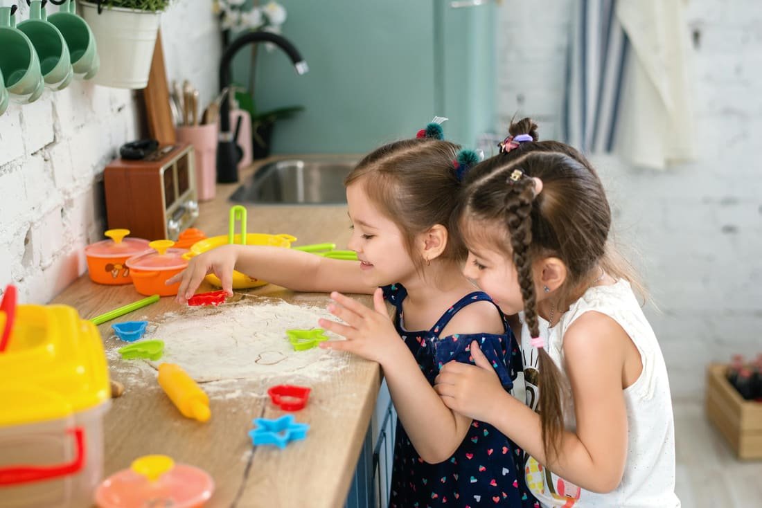 Dos niñas jugando con masa y moldes de colores